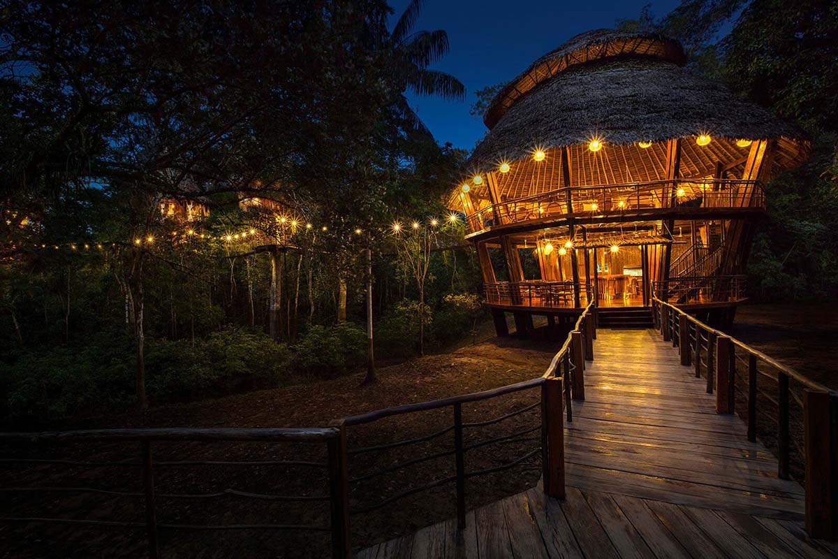 The dining hall at Treehouse Lodge in the Iquitos jungle lit up at night.